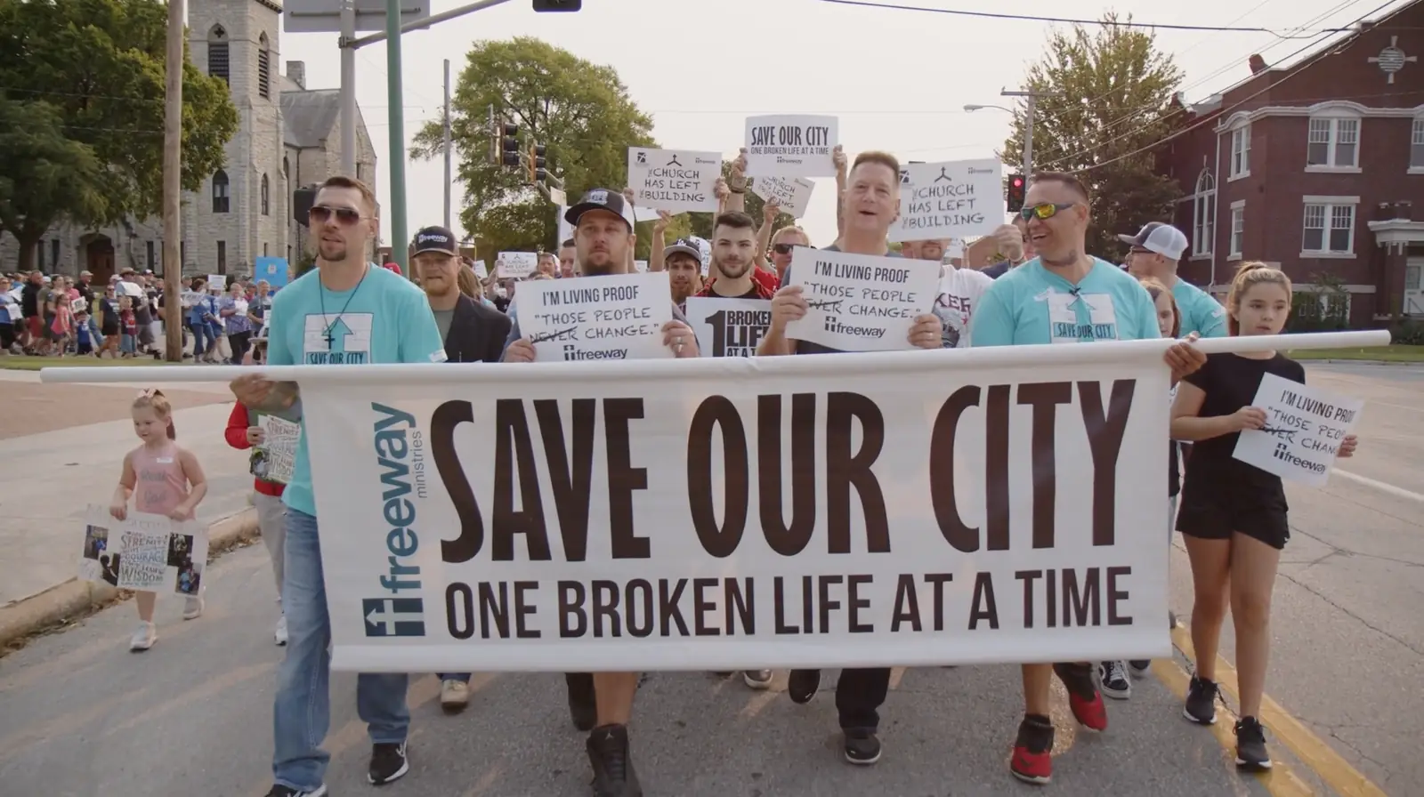 Marchers carrying a Save Our City, One Broken Life at a Time banner