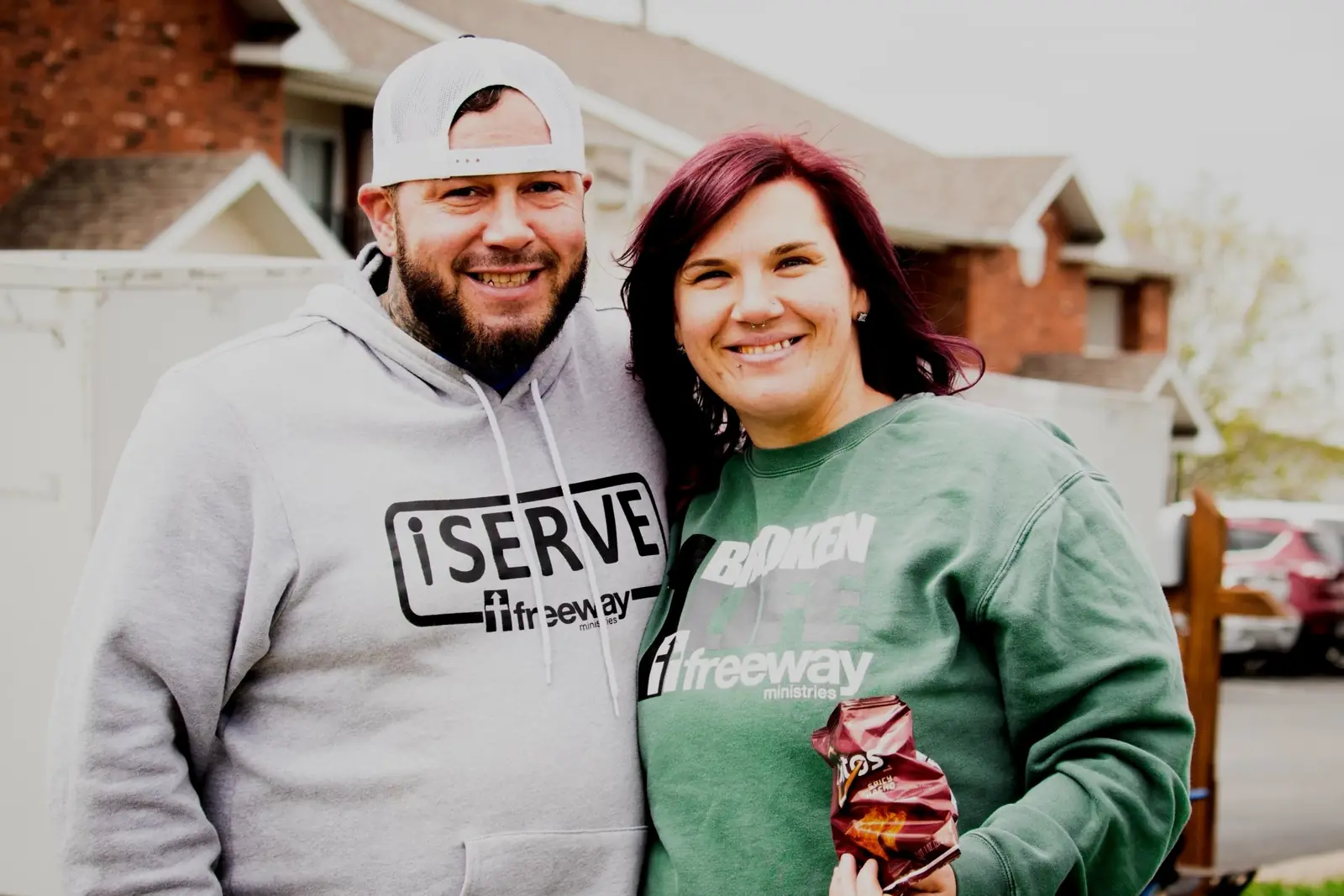 Two smiling Freeway volunteers in serve shirts