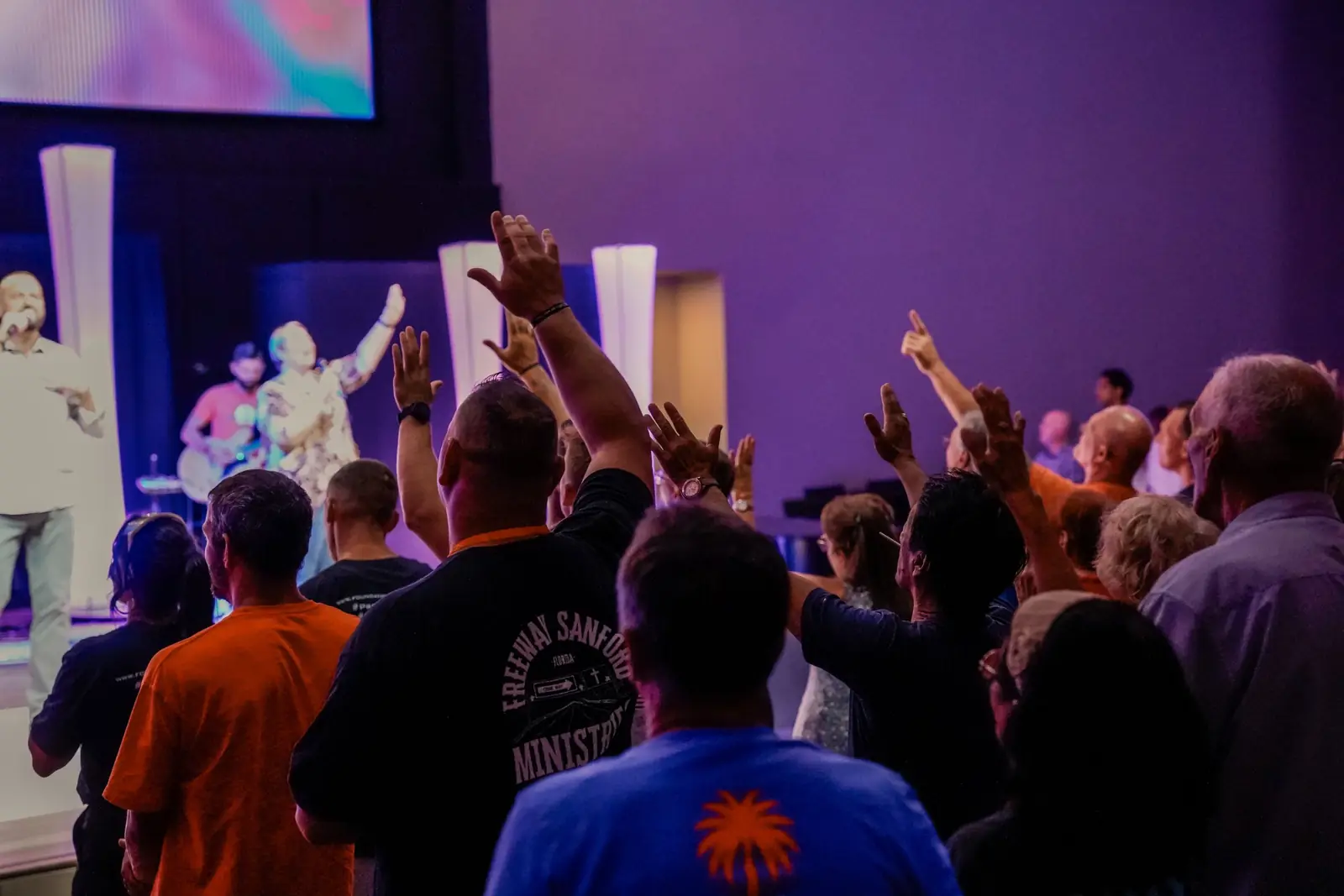 Hands raised in worship at a Saturday night service